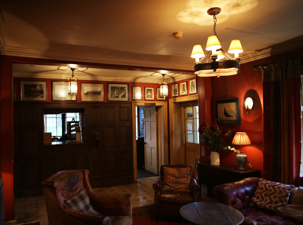 The Gunton Arms The welcoming entrance hall with a blazing fire and lovely leather furniture. 