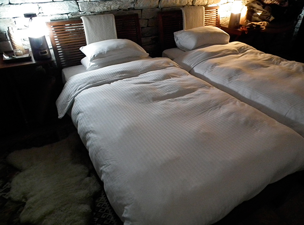 360º Leti Beds freshly turned down with solar lamps at the bedside.