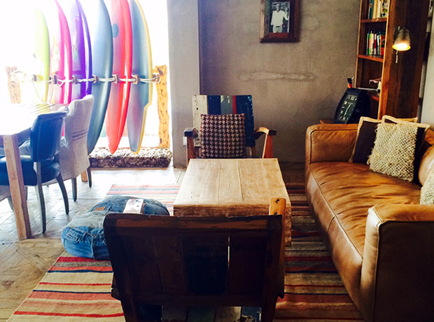 Surfers Lodge Peniche Reclaimed wood, denim ottomans, leather, custom-shaped boards and rolling surf footage…the most cosy of living rooms.