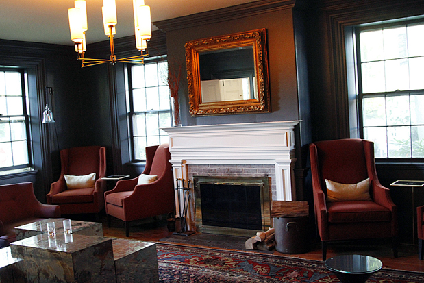 The Captain Fairfield Inn The chic and sultry sitting room, complete with fireplace. Those red chairs are the perfect nook to peruse the paper, curl up with a book, a cup of tea, and one of the inn’s warm, homemade chocolate chip cookies.