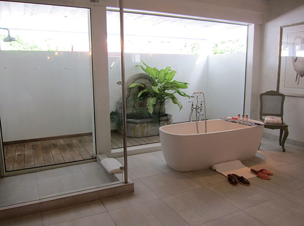 Cheval Blanc Isle de France Soaking tub, indoor and outdoor shower with his and her size slippers and robes to match.