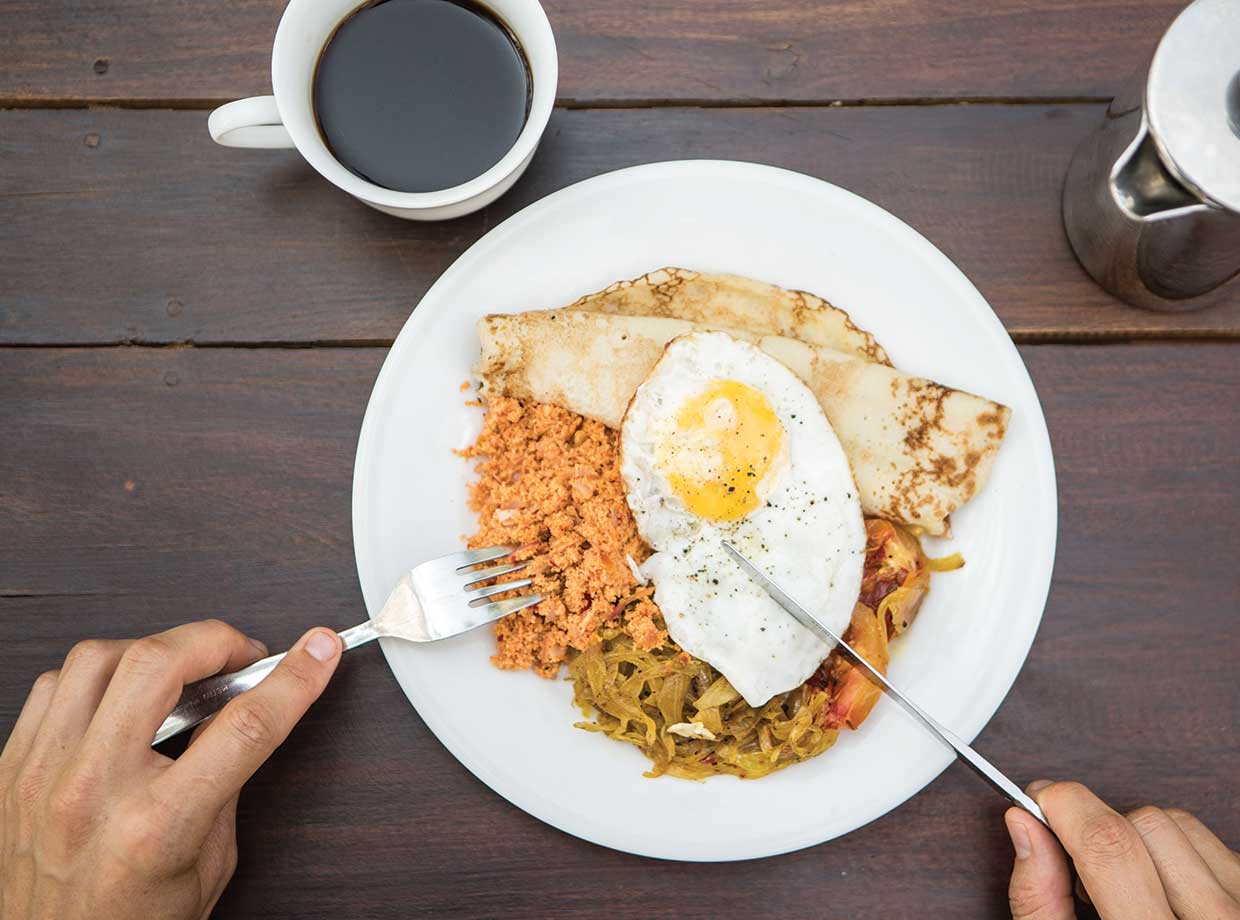 Talalla Retreat Incredible Sri Lanka breakfast of pancakes with a fried egg, sweet onion relish and coconut sambal. 