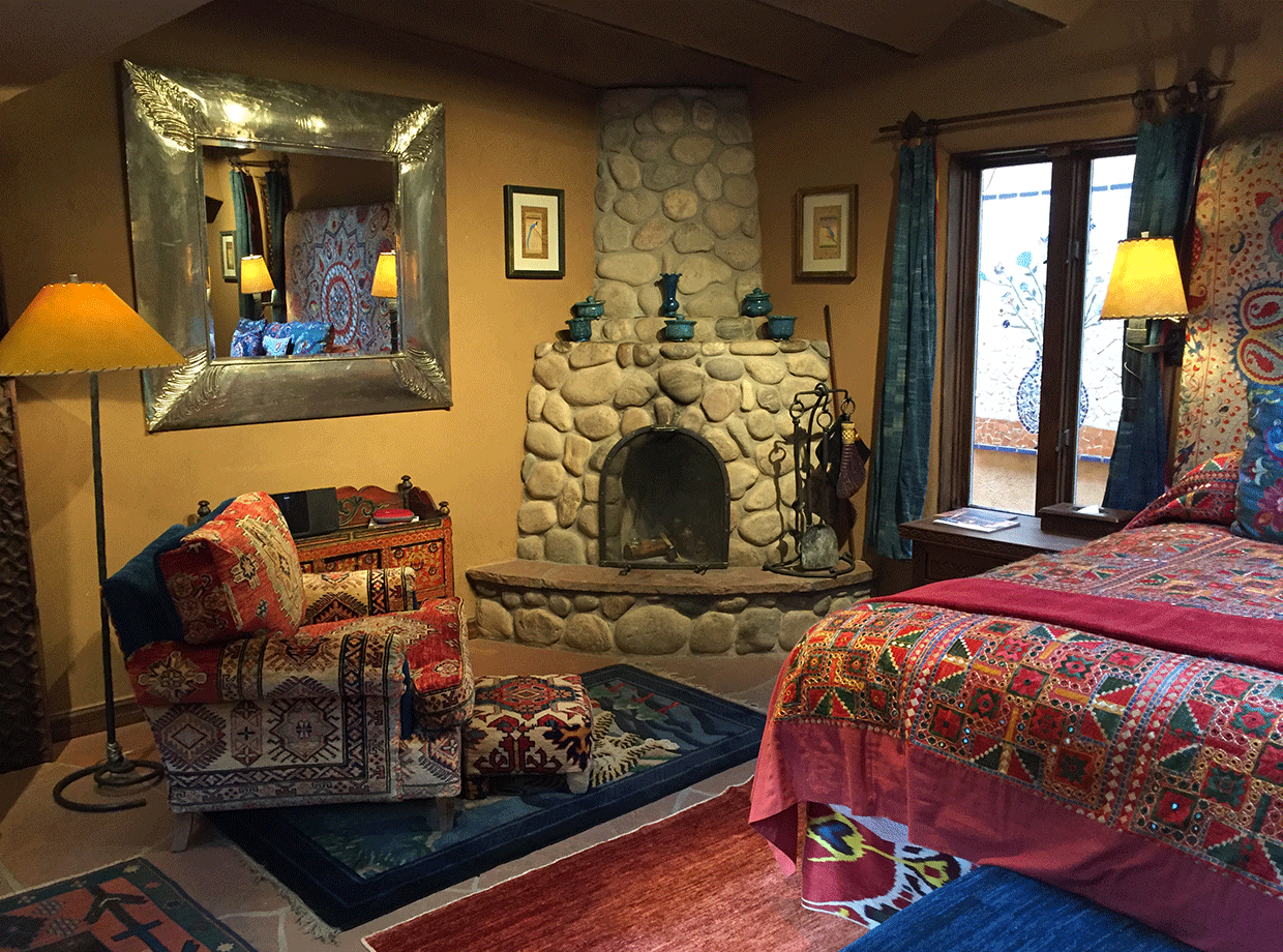 The Inn of Five Graces More of the room with incredibly elaborate finishes - stone fireplace, sofa, rugs. 