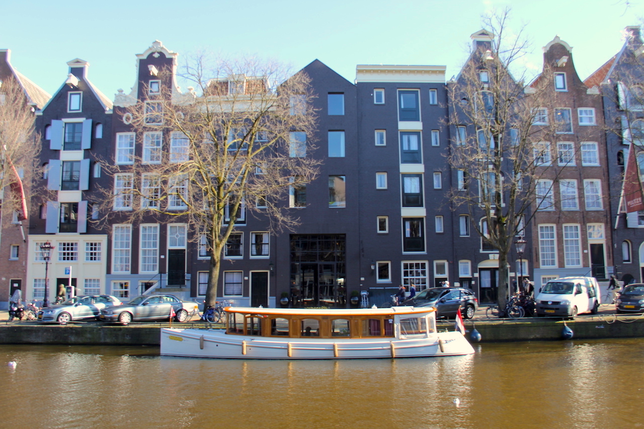 Pulitzer Amsterdam The hotel from across the street, with its own boat ready to take people around the canals. 
