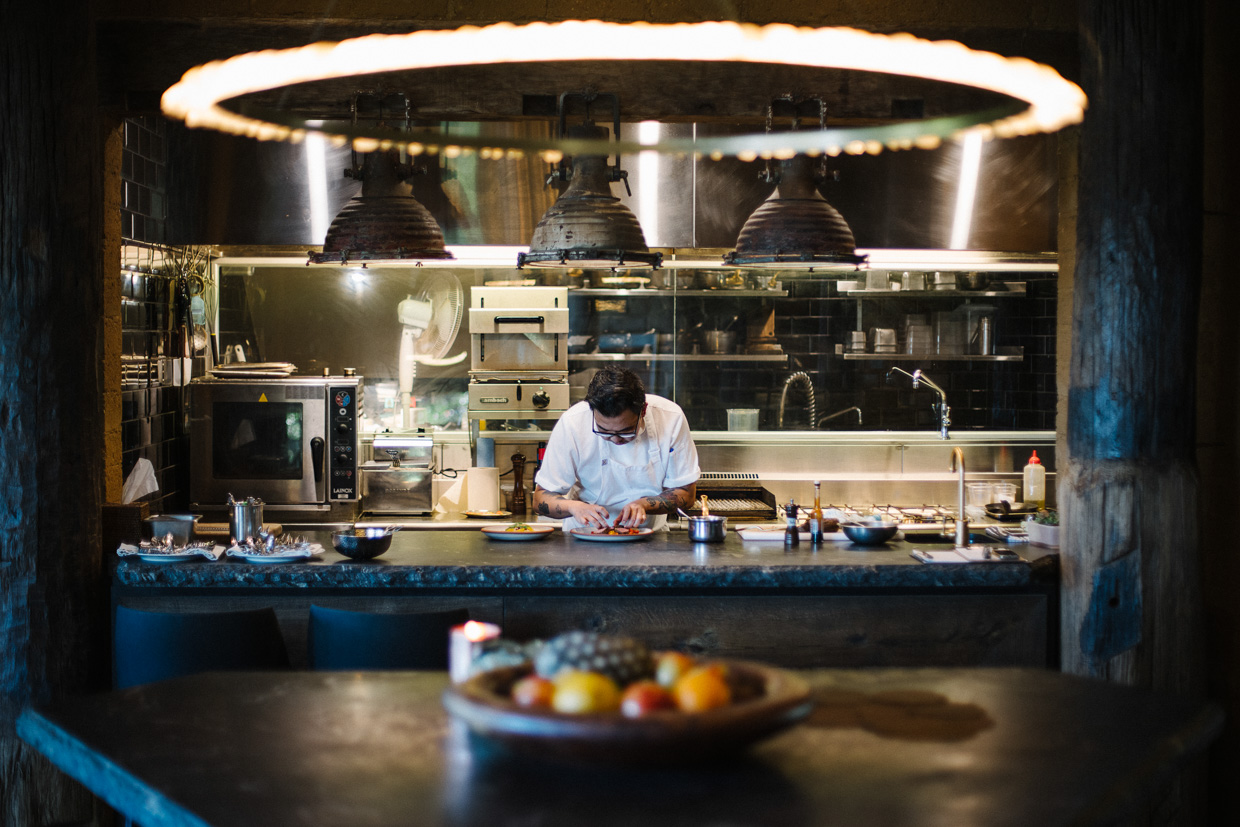 Pretty Beach House Chef preparing food in the open kitchen. 