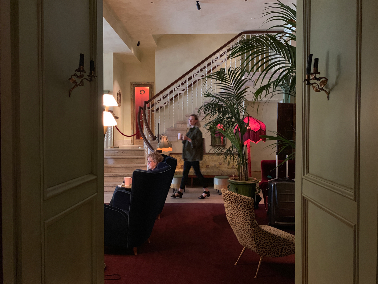 The Siren Hotel A few original details remain: the staircase, the travertine floors, the terracotta signs and the piece of ceiling at the entrance. Also, see that phone booth behind me? If you pick it up, it calls a phone booth in the lobby of one of ASH NYC’s other hotels, The Dean in Providence, RI, or Hotel Peter and Paul in New Orleans. 
