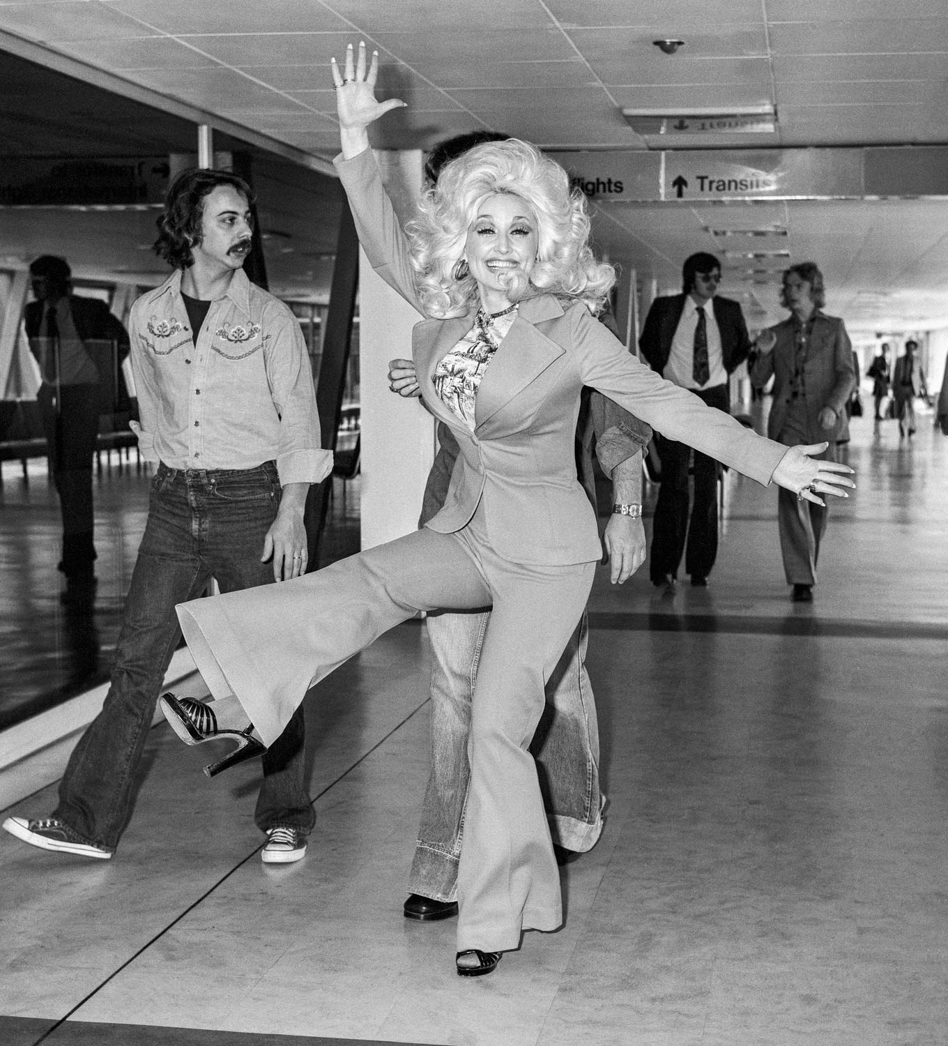 Dolly Parton leaving London's Heathrow Airport after performing at Wembley Stadium, 1976