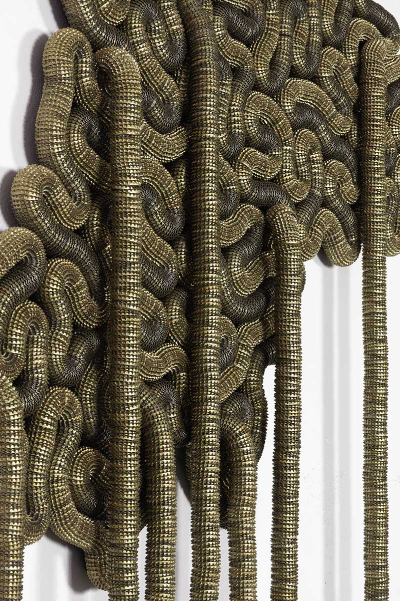 Discarded beer bottle caps threaded onto electrical fencing cable and adhered to board.