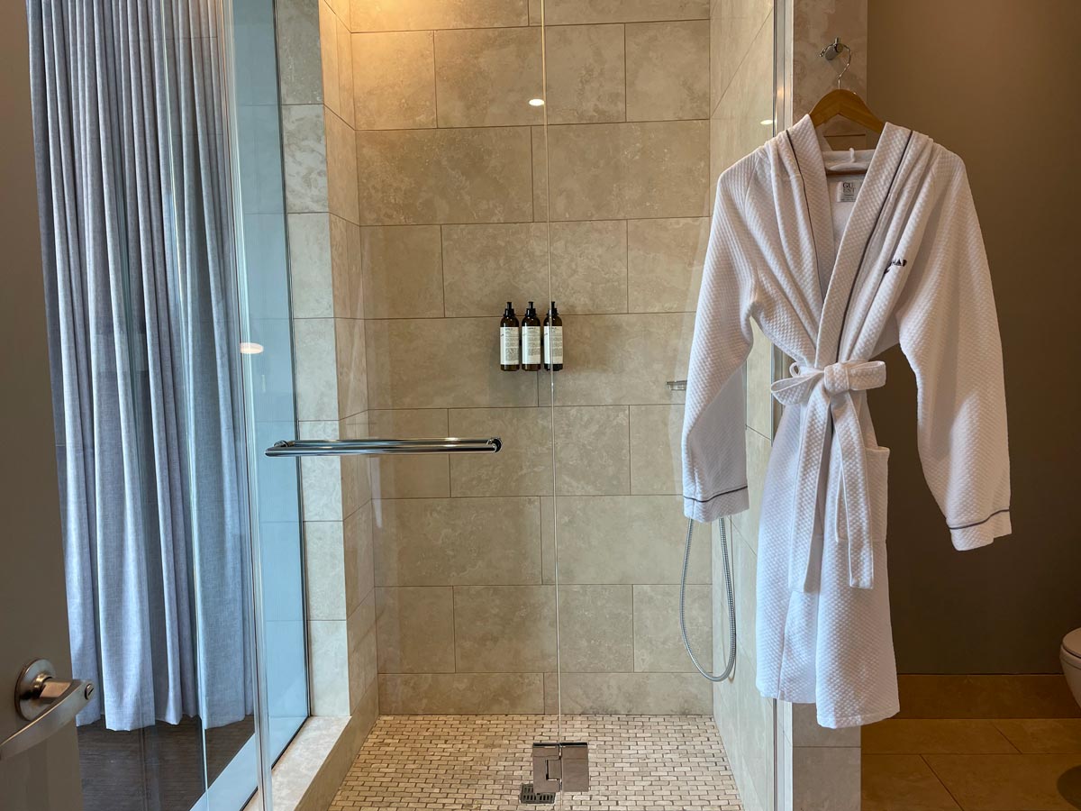 ModernHaus SoHo Bathroom stocked with all the right things: soft robe, high pressure shower and toiletries in refillable containers