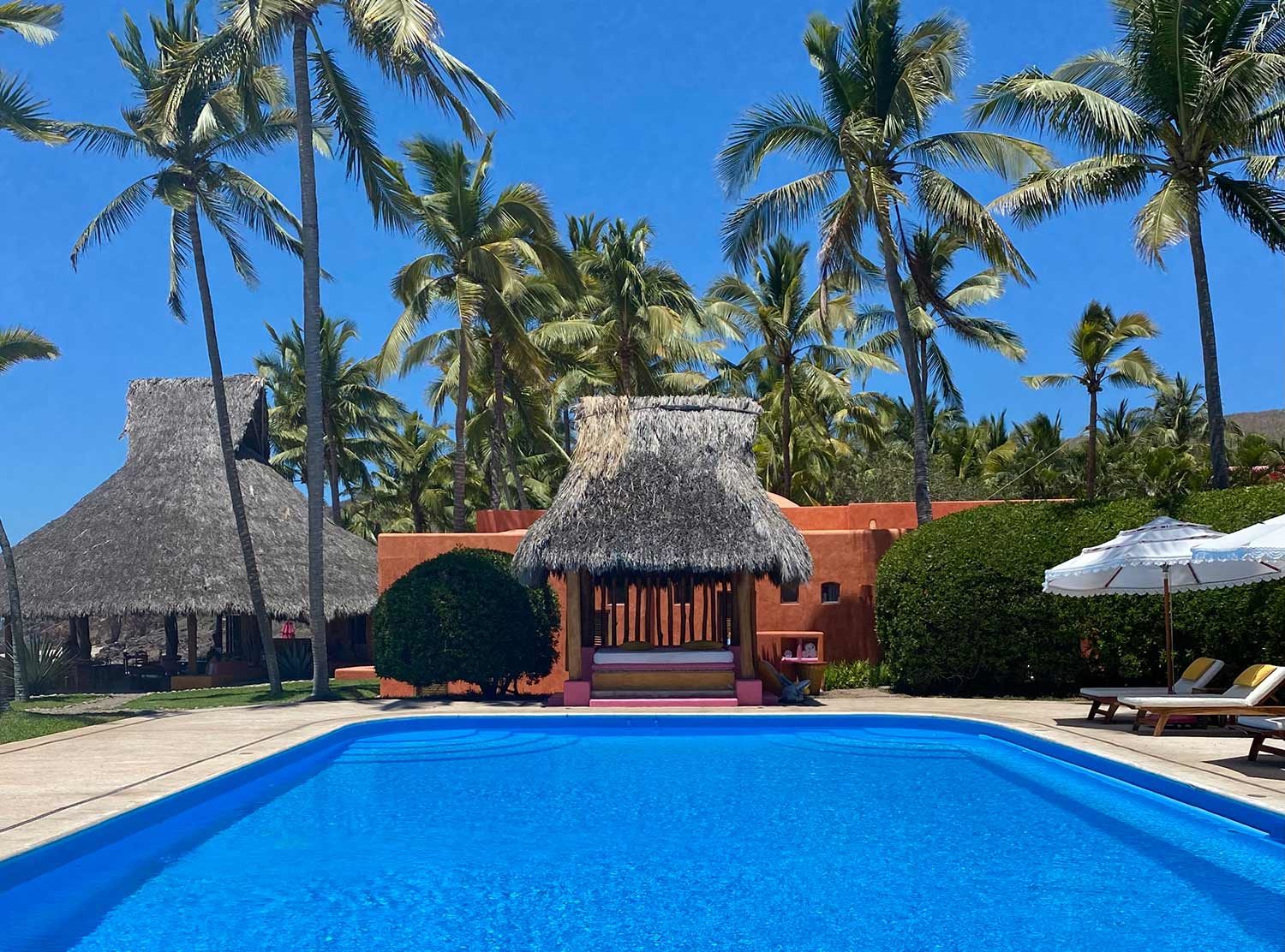 Las Alamandas Love the strong hue of the pool against the orange walls behind. On the left is La Palapa Beach Club