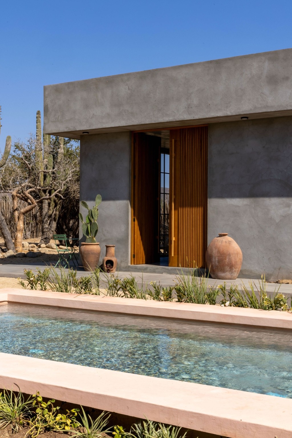 All rooms have two independent entrances, one of them opening up to the pool via the custom-made wood doors designed by Ben Pundole.