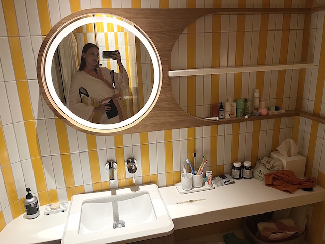 The Standard Singapore Indulging in bathrobe time whilst appreciating the bold yellow tiles and funky mirror shelving situation