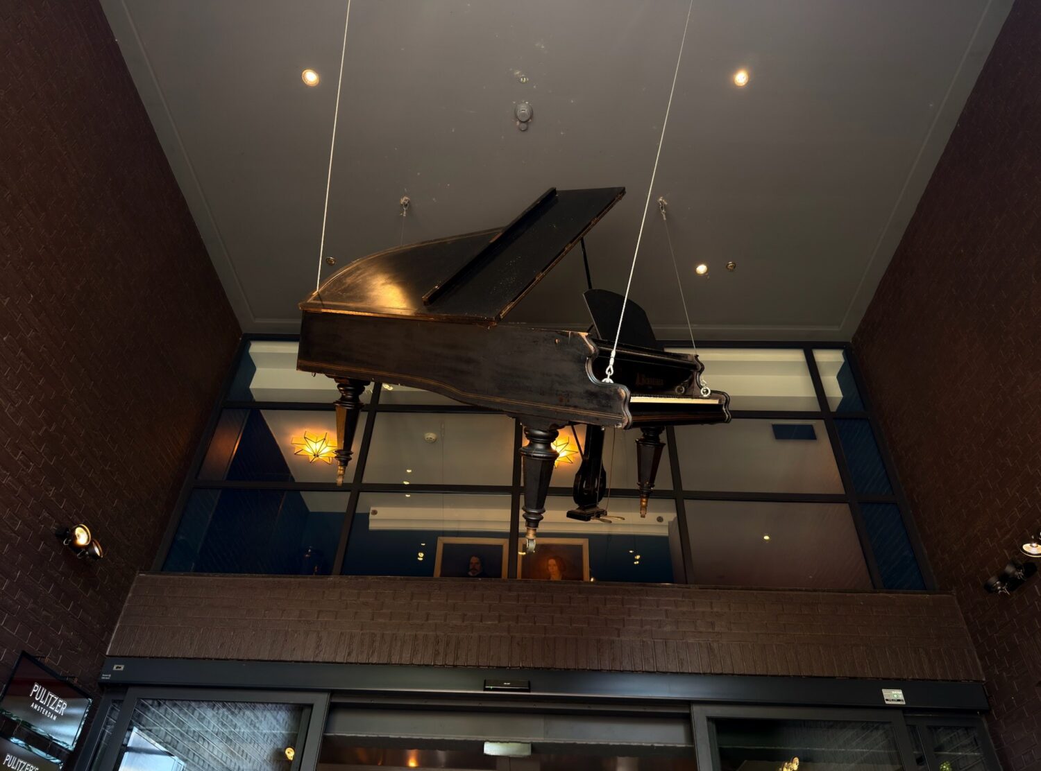 Pulitzer Amsterdam A precarious and charming art installation of the piano suspended in the entrance 