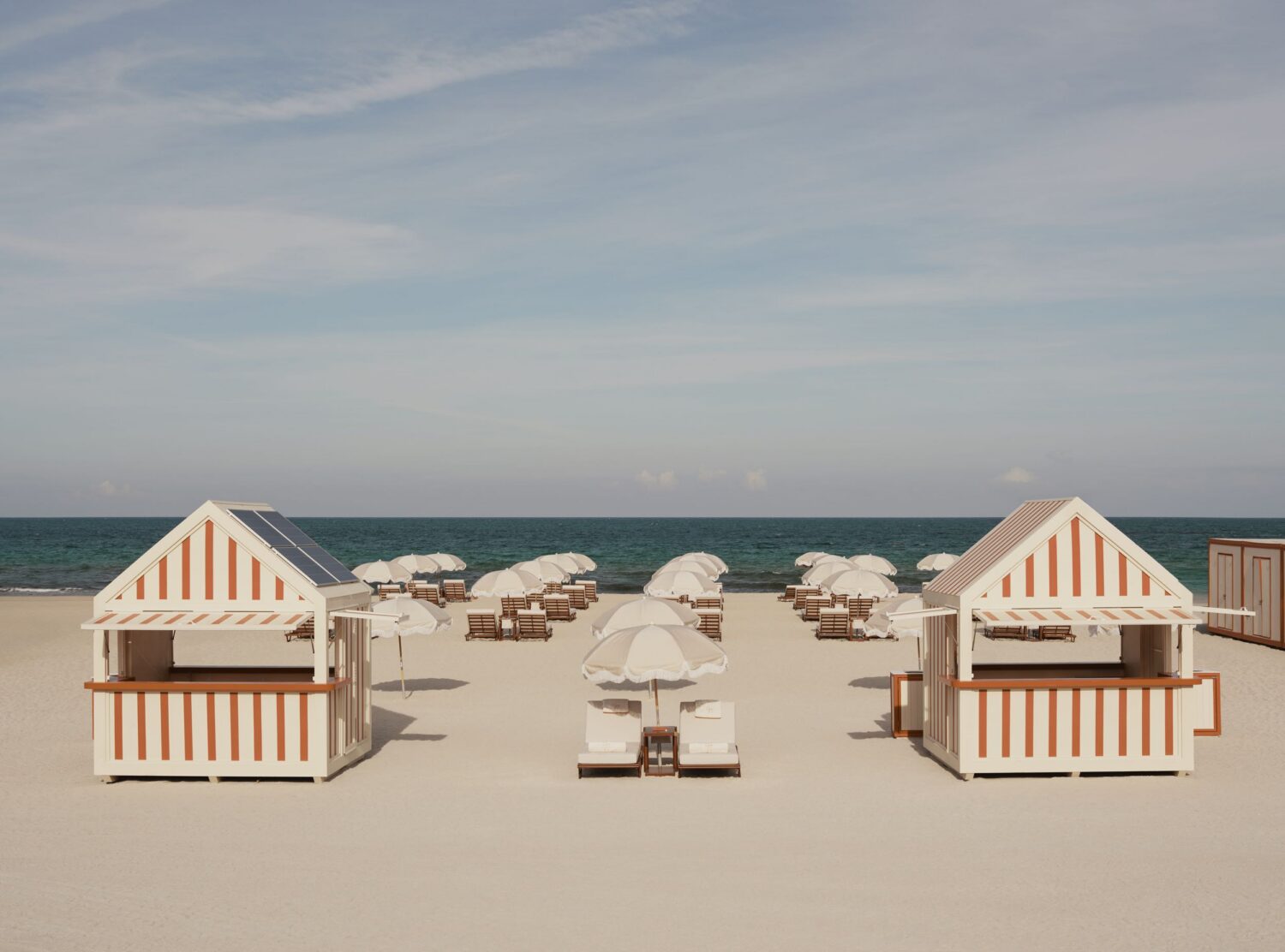 Delano Miami Beach The orange-and-white striped kiosks on the Delano's beach repeat a beach club visual code dating back to Miami Beach's earliest decades of tourism. One detail updates the scene: a discreet solar panel built into the roof, proof that even the hotel's most nostalgic gesture carries, today, a contemporary twist.