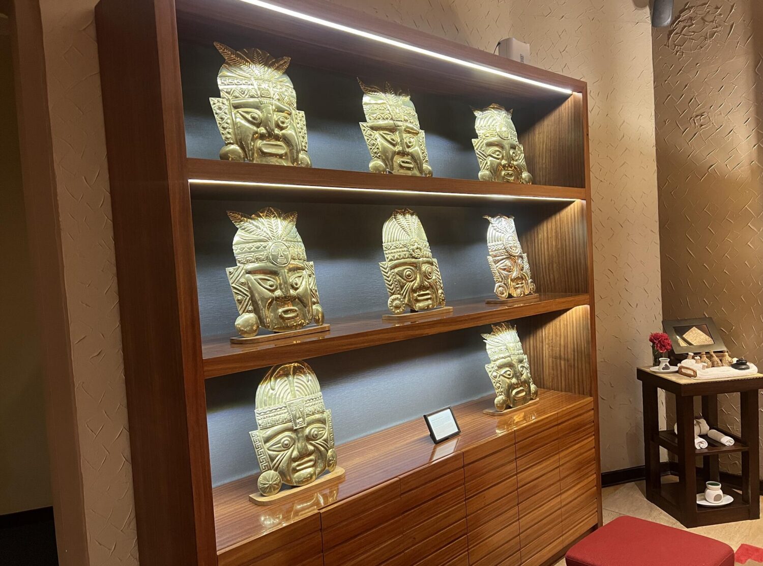 Sumaq Machu Picchu Hotel Gold Andean masks lining the lobby shelves