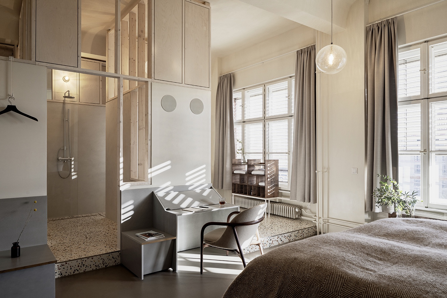 The Luxus rooms, designed by Jonathan Tuckey Design Studio, feature a tactile, architectural narrative focused on understated luxury and natural textures. They leave the original building's original sculptural concrete beams and massive warehouse windows exposed.