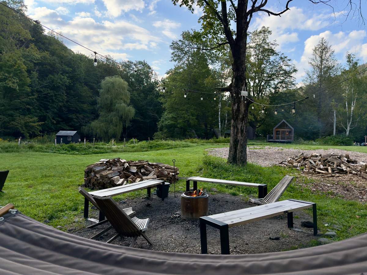 Eastwind Oliverea Valley Our private outdoor space: a fire pit, simple black benches, stacked wood and a wide meadow running toward the trees. This was where the day slowed down and the three of us could simply be together